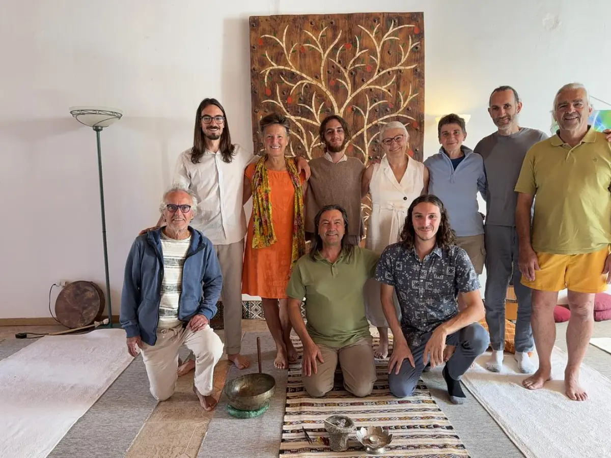 Membres de la communauté réunis dans une salle de stage, devant un arbre de vie sculpté